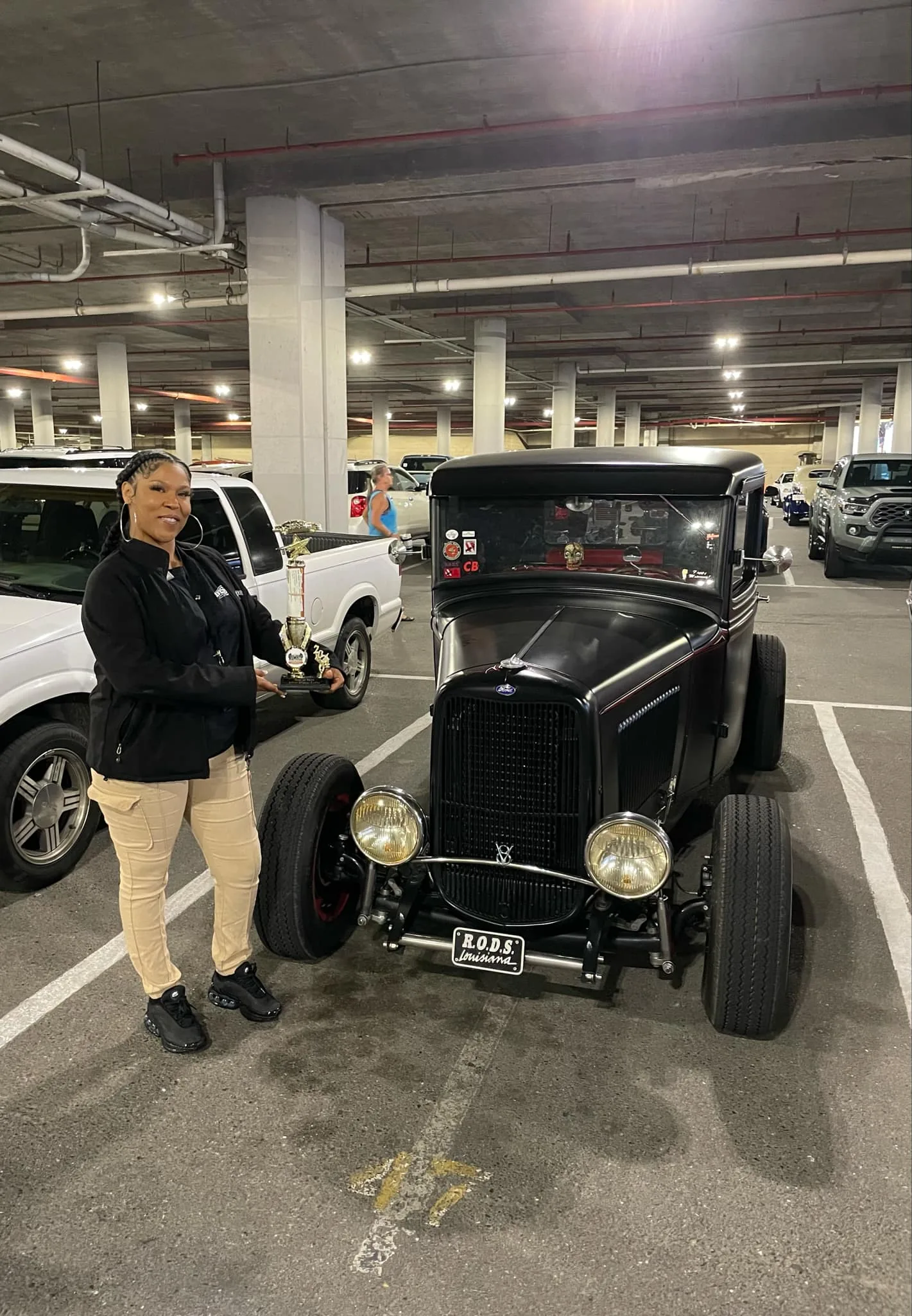 Prize winner standing beside a black classic car