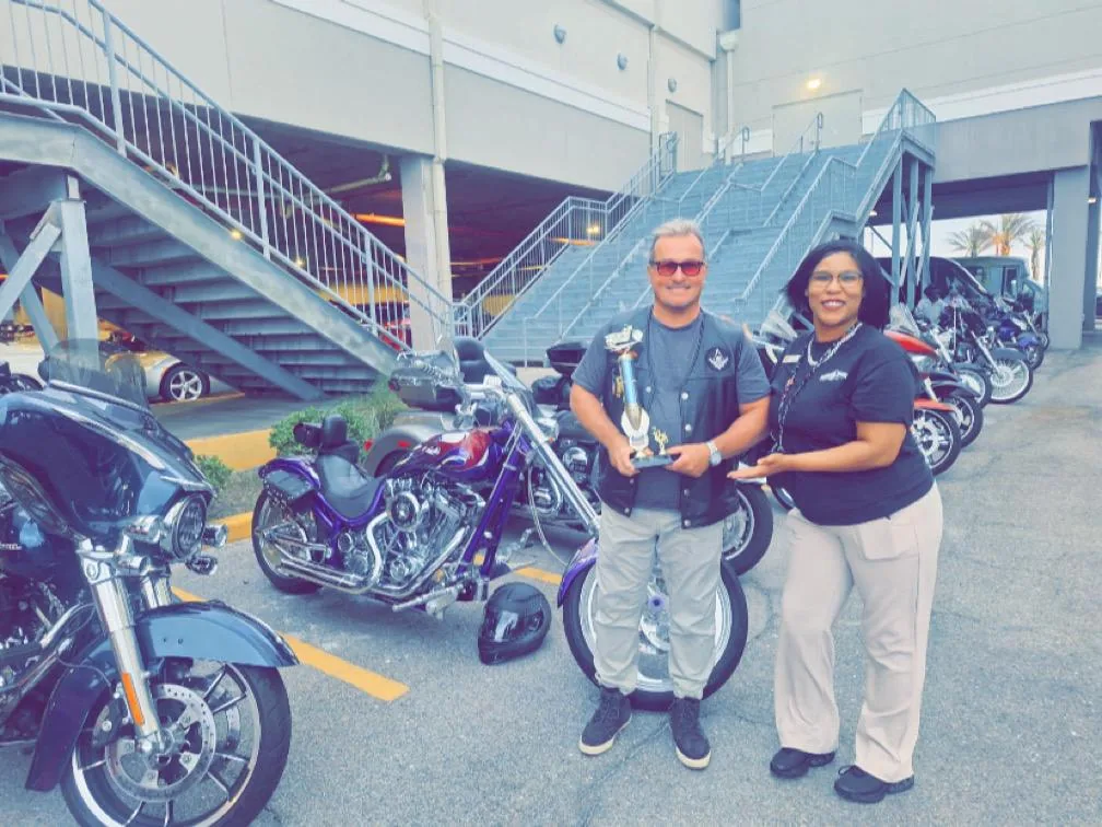 Two prize winners with motorcycles outside Silver Slipper